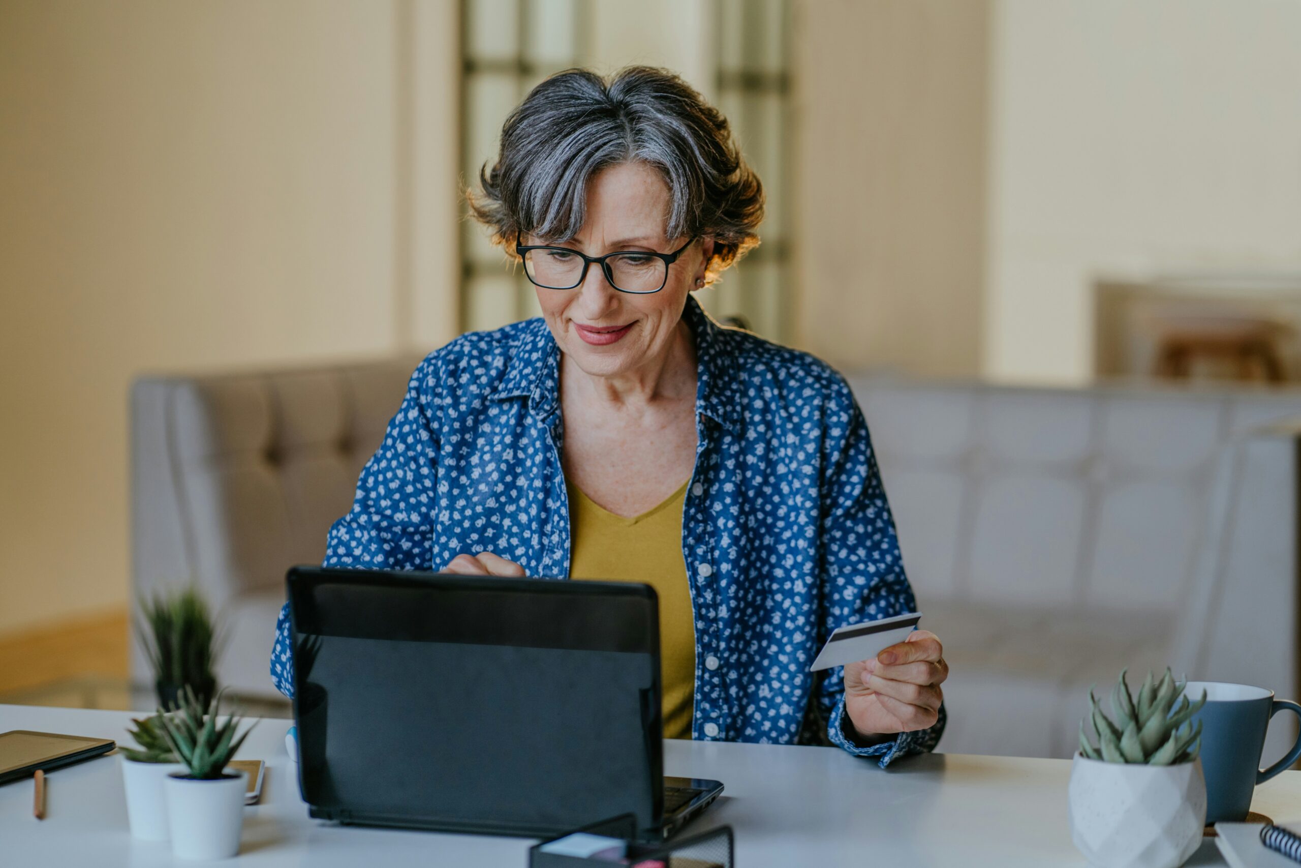Senior woman reviewing new Medicaid work requirements online at her table