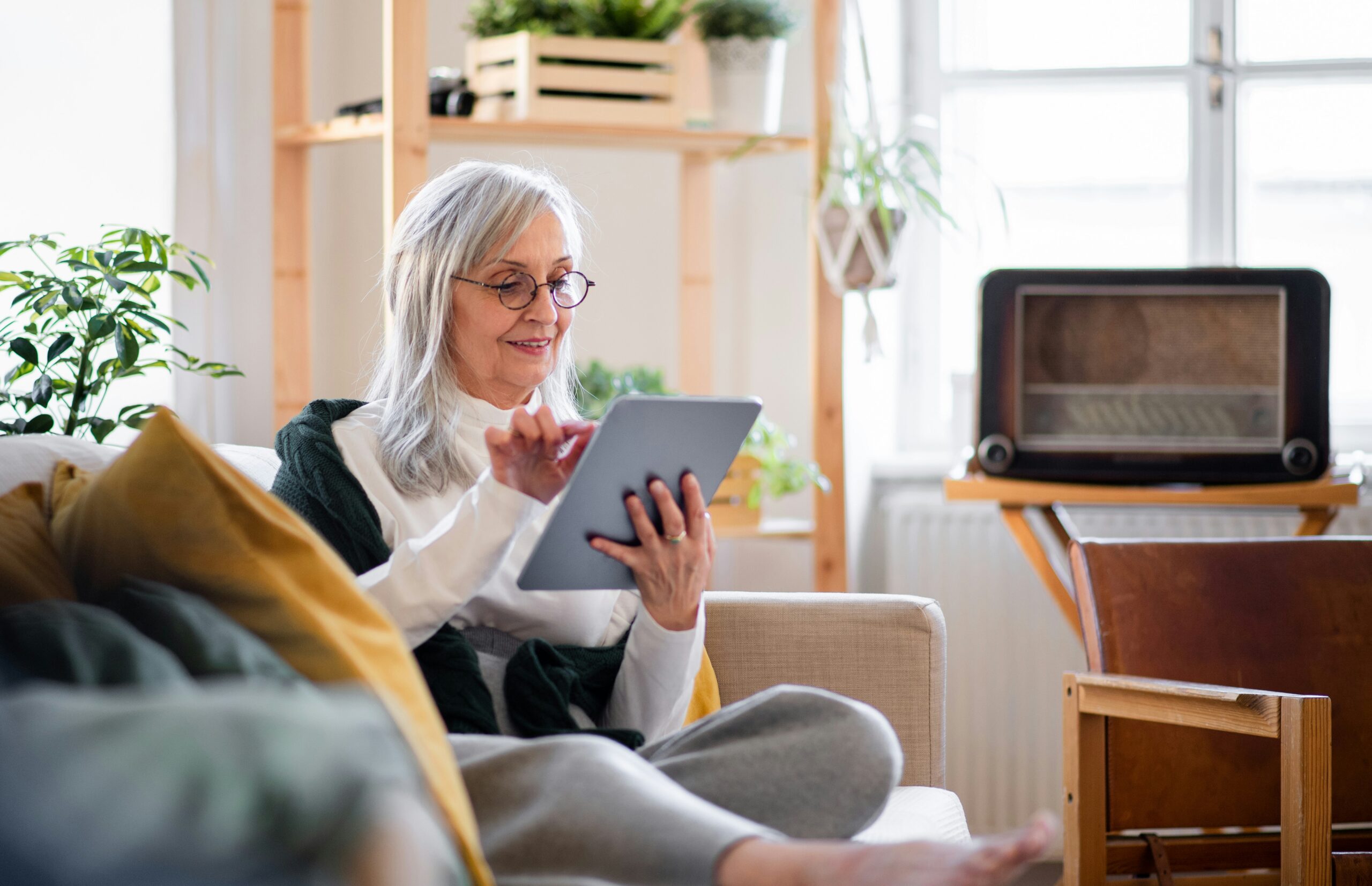 Older woman using a tablet at home to research Medicaid changes in New York